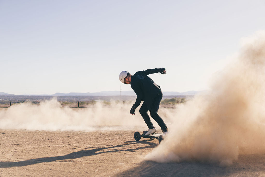 Rider kicking up dust on an ONSRA VELAR in the desert